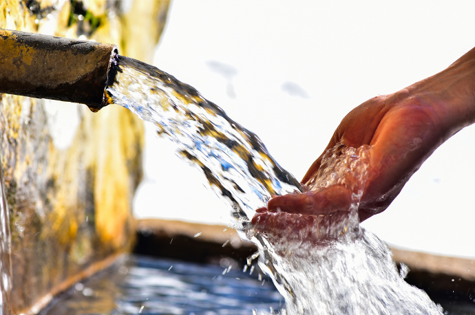 image d'une main sous une fontaine illustration pour eau de Grenoble matière première de notre produit